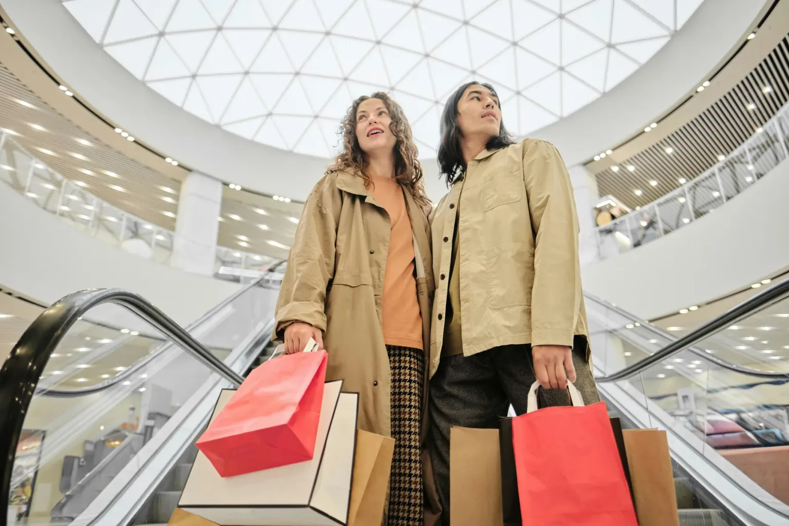 Shoppers carrying bags through a modern shopping center