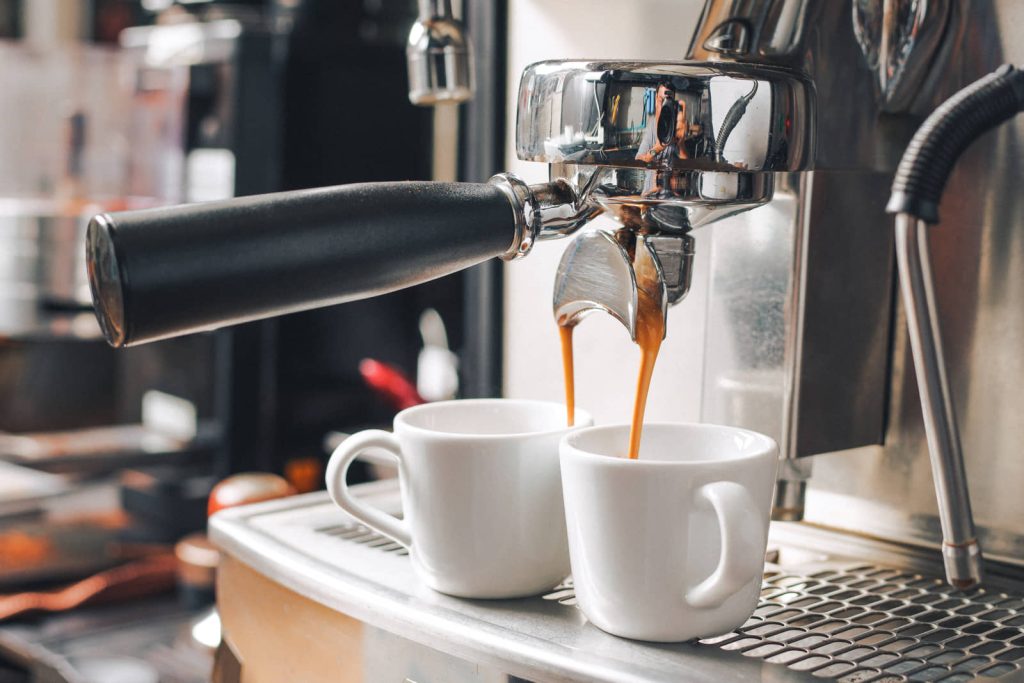 Espresso machine pouring fresh coffee into two cups