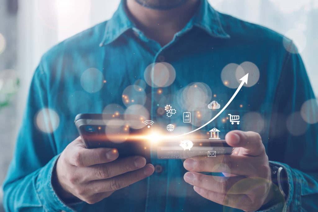 Person holding a smartphone with connected-service icons and a rising growth curve