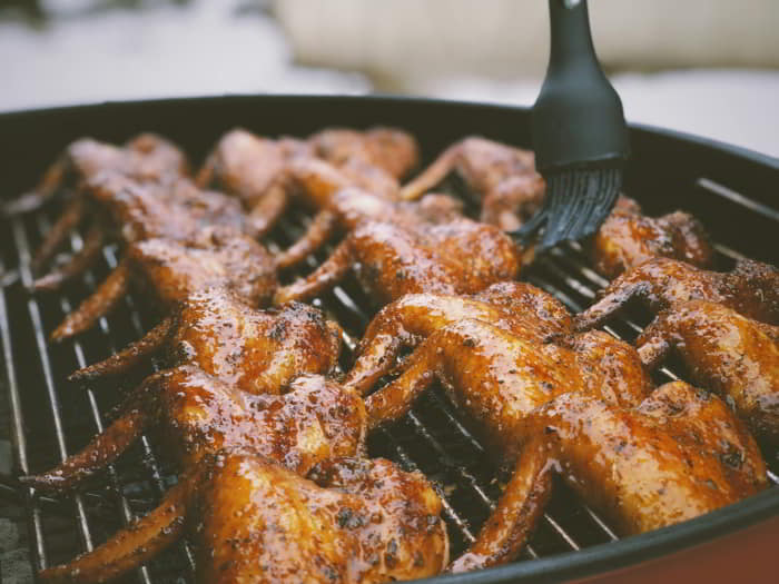 BBQ sauce being brushed onto grilled food