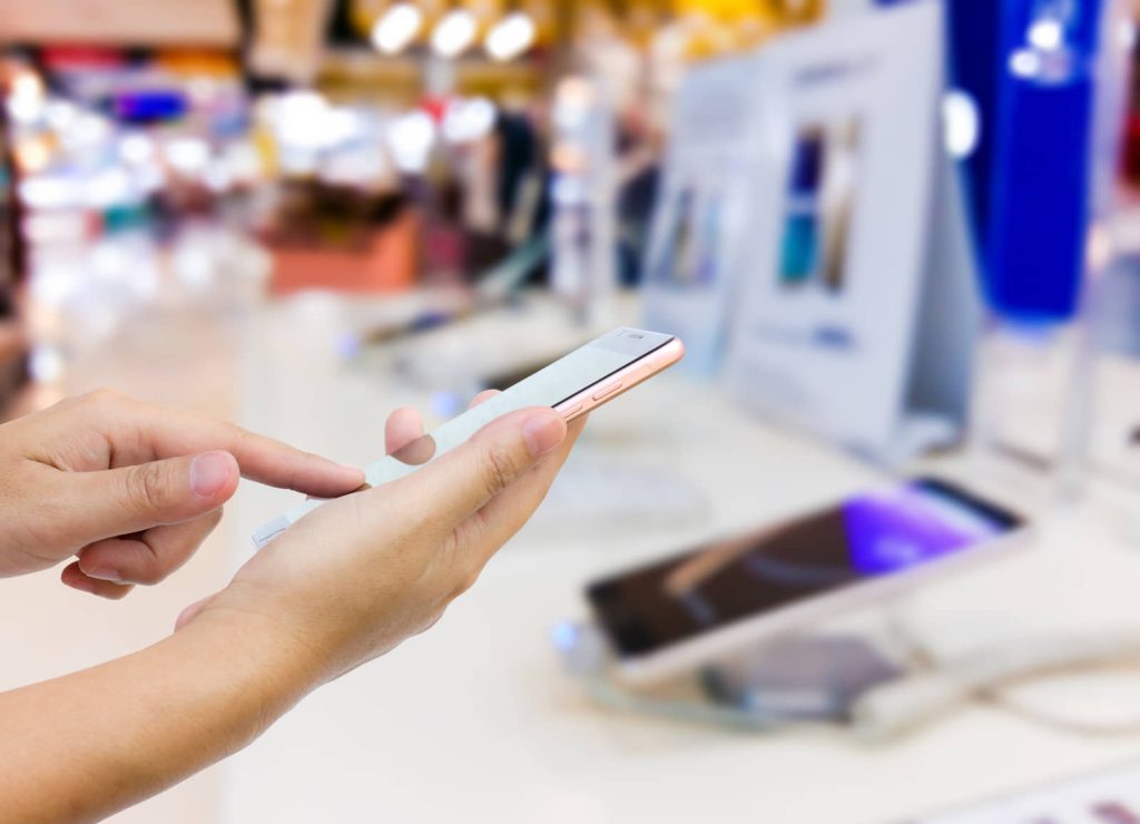 Customer trying a smartphone at a telecom retail display