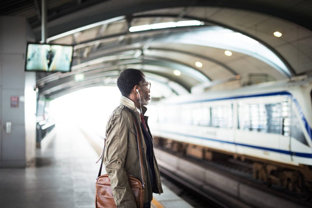 Commuter waiting on a rail platform as a train arrives