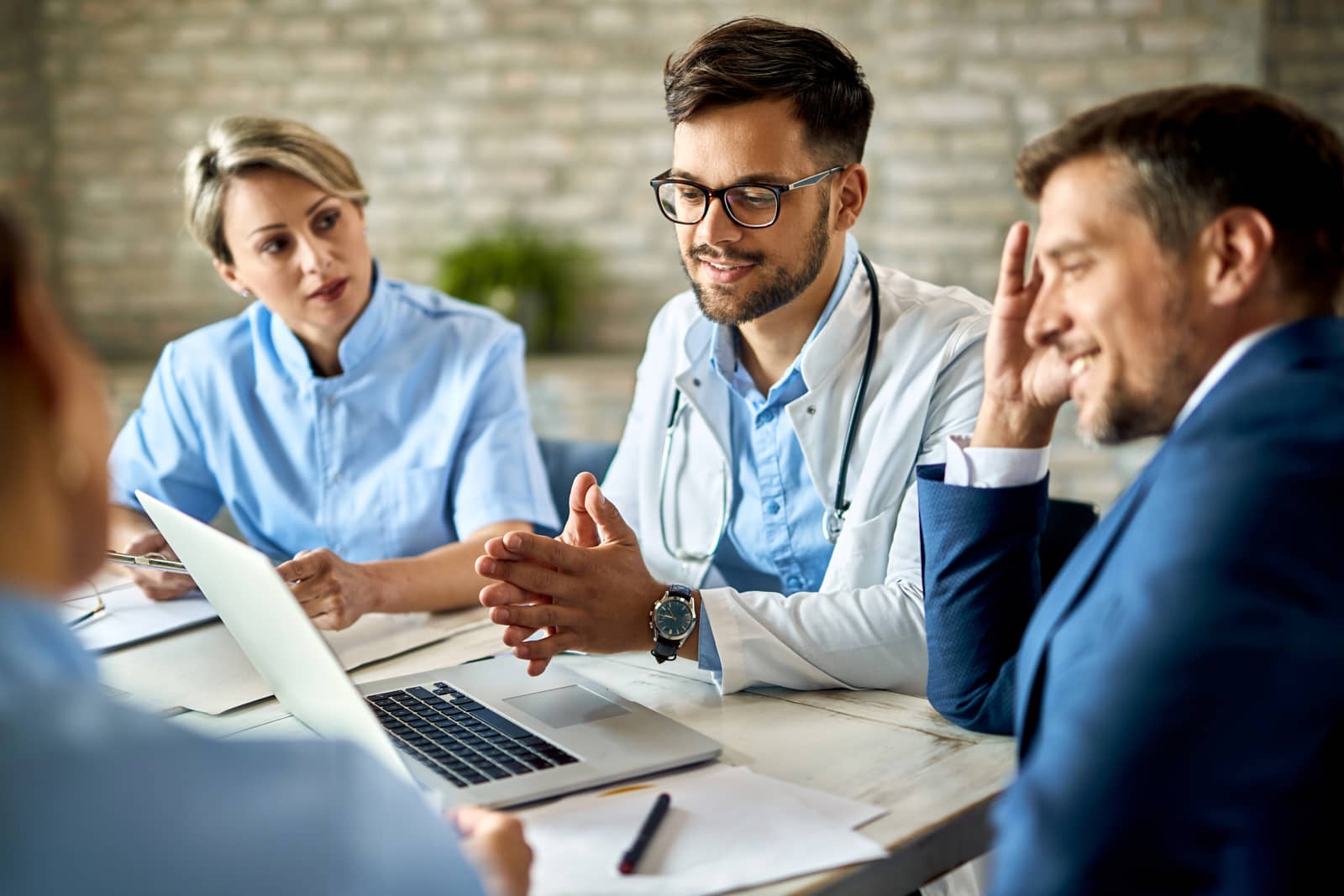 Healthcare team meeting around a laptop