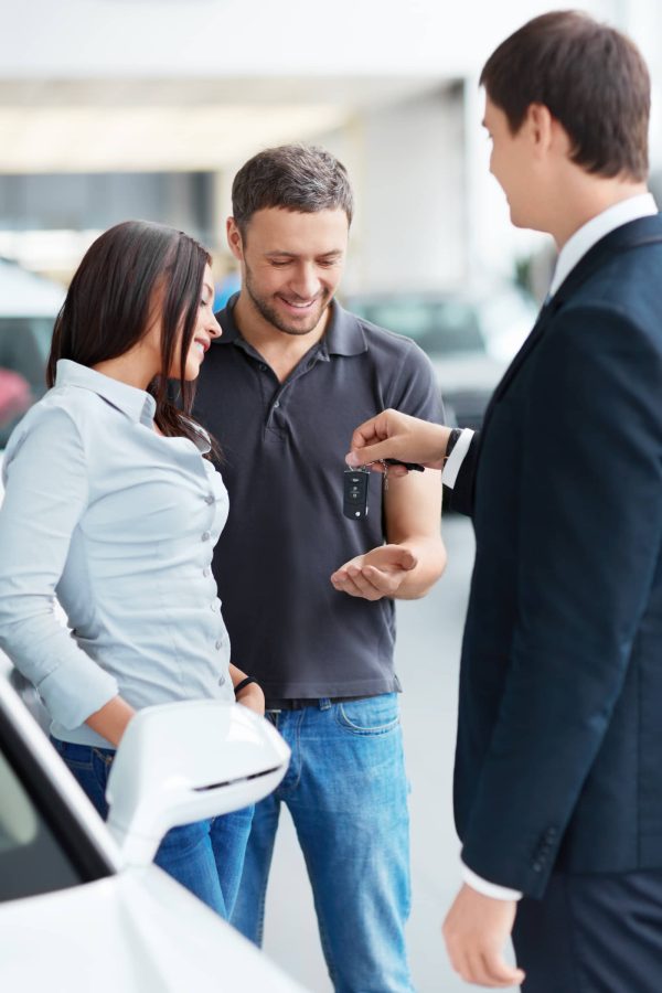 Couple receiving car keys at a dealership